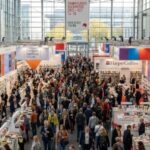 Thousands of visitors and publishing professionals exploring book displays and exhibitor stands inside the vast halls of Messe Frankfurt during the Frankfurt Book Fair 2026 in October