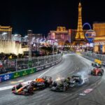 F1 cars racing down the Las Vegas Strip at night during the Grand Prix