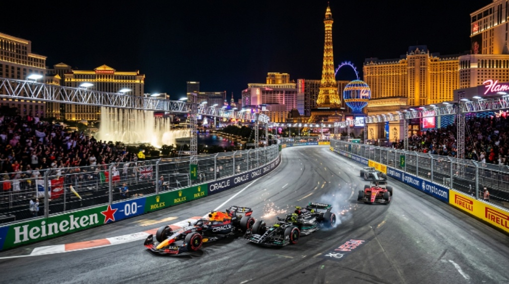 F1 cars racing down the Las Vegas Strip at night during the Grand Prix