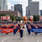 Marching band performing at the H-E-B Thanksgiving Day Parade in downtown Houston