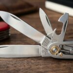 Red Swiss Army Knife opened on a wooden desk with EDC gear.