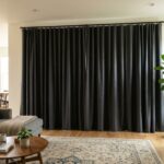 Dark gray blackout curtains covering a large glass sliding patio door.